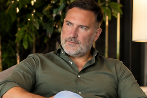 Carsten Meyer im olivgrünen Poloshirt, sitzend in einer modernen Umgebung mit Pflanzen im Hintergrund.